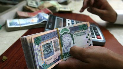 موظف يحسب أوراقاً نقدية سعودية من فئة 500 ريال، في مكتب للصرافة، الرياض، السعودية - رويترز 