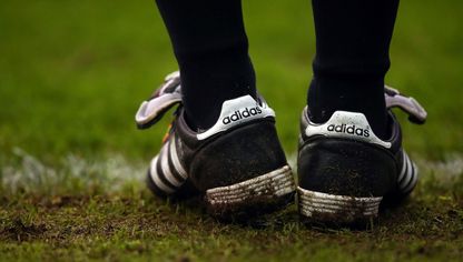 حذاء رياضي من صناعة "أديداس" يلبسه حكم خط التماس في إحدى مباريات الدوري الإنجليزي - المصدر:  "غيتي ايمجز"