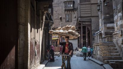 شاب يحمل الخبز بينما يقود دراجته في القاهرة.. يعتمد ملايين المصريين على الدعم الحكومي للسلع الأساسية - المصدر: بلومبرغ