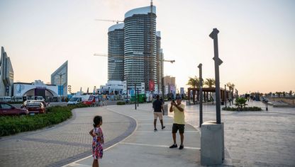 زوار يلتقطون صوراً أمام بوابة مهرجان العلمين الجديدة ومشروعات السكن في مدينة العلمين الجديدة، في محافظة مطروح، مصر، يوم الخميس، 24 أغسطس 2023 - المصدر: بلومبرغ