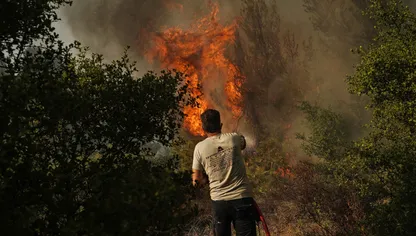 متطوع يعمل على إخماد حرائق الغابات المشتعلة قرب مدينة ستاماتا، شمال شرق أثينا، اليونان في 30 يونيو 2024 - بلومبرغ