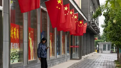 أعلام الصين تزين واجهة أحد المتاجر في مدينة هانتشونغ، مقاطعة شنشي، الصين - بلومبرغ