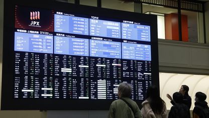 زوار أمام لوحة إلكترونية لتداول الأسهم في بورصة طوكيو باليابان - بلومبرغ
