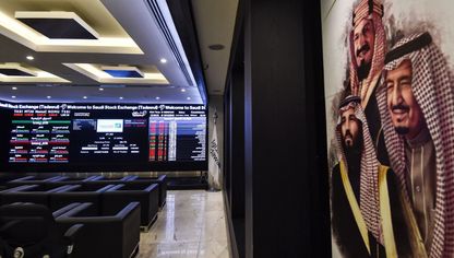 صورة من داخل قاعة في سوق الأسهم السعودية (تداول) فيما تظهر على الجدار الأيمن لوحة فنية تحمل صور مؤسس المملكة العربية السعودية الراحل الملك عبد العزيز آل سعود، والملك سلمان بن عبد العزيز، وولي عهده الأمير محمد بن سلمان. الرياض المملكة العربية السعودية. - AFP
