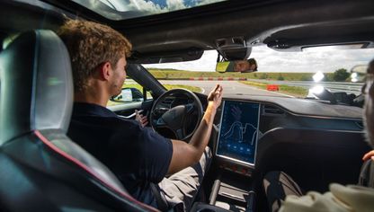 سائق اختبار يرفع يديه عن عجلة القيادة في سيارة تسلا الكهربائية من طراز S مزودة بتقنية القيادة الذاتية - المصدر: بلومبرغ