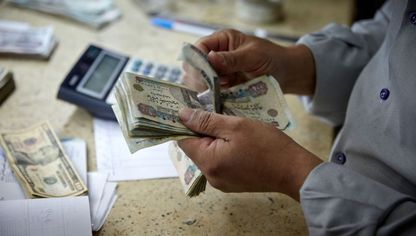 موظف يعد أوراقاً نقدية من الجنيه المصري بمكتب صرف للعملات الأجنبية في القاهرة، مصر. - المصدر: بلومبرغ