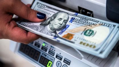 موظفة تعد أوراقاً من الدولار الأميركي - المصدر: بلومبرغ