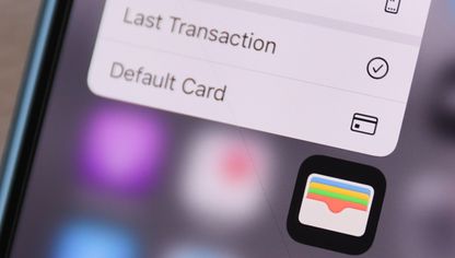 شاشة هاتف ذكي تظهر عليها أيقونة تطبيق المحافظ الرقمية (Apple Wallet)، مع جزء من القائمة الخاصة بالتطبيق والتي تشمل خيارات مثل "أحدث عملية" و"البطاقة الافتراضية" - المصدر: بلومبرغ