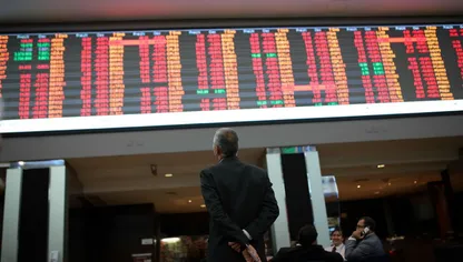 مراقب لشاشة تعرض أسعار أوراق مالية - المصدر: بلومبرغ