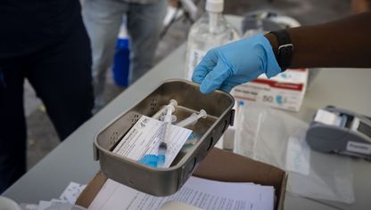 عامل رعاية صحية يحمل جرعة لقاح - المصدر: بلومبرغ