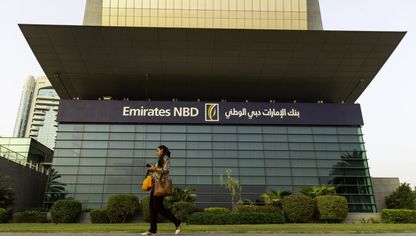  سيدة تمر من أمام المكتب الرئيسي لبنك الإمارات دبي الوطني في دبي، الإمارات العربية المتحدة  - المصدر: بلومبرغ