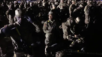 متدربون من الجيش الأميركي يتجمعون في ساعات ما قبل الفجر بعد تدريبات ميدانية شاقة استمرت 81 ساعة تُعرف باسم "فورج" وقبل بدء مراسم الاحتفال بالجندي في كولومبيا بولاية كارولينا الجنوبية. - المصدر: بلومبرغ