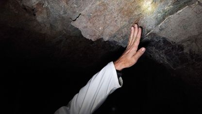 شخص يفحص صخوراً تحتوي على معادن نادرة - بلومبرغ