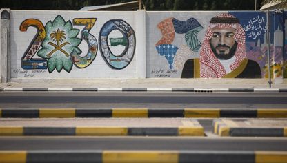 جدارية تعرض شعار رؤية 2030 وولي العهد السعودي الأمير محمد بن سلمان في الظهران، السعودية - المصدر: بلومبرغ