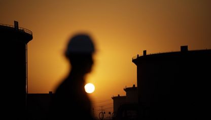الشمس تغرب خلف صهاريج تخزين النفط الخام في مصفاة نفط رأس تنورة التابعة لشركة أرامكو السعودية - المصدر: بلومبرغ