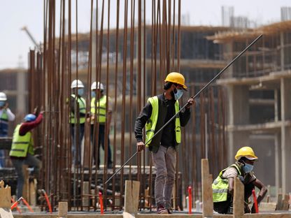 عمال يرتدون كمامات واقية يجهزون الهيكل الحديدي لمبنى قيد الإنشاء في العاصمة الإدارية الجديدة، شرق القاهرة. مصر - المصدر: رويترز