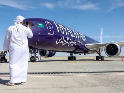 زائر  بـ\"معرض دبي للطيران\" يلتقط بهاتفه الذكي صورة لطائرة \"بوينغ\" طراز \"787-9 دريملاينر\" تشغلها شركة \"طيران الرياض\" 13 نوفمبر 2023 - المصدر: بلومبرغ