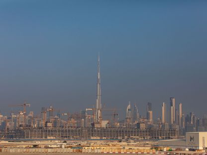 رافعات البناء تعمل في موقع تطوير مركز \"ميدان ون\" الضخم بدبي فيما يلوح في الأفق برج خليفة أعلى ناطحة سحاب في العالم - المصدر: بلومبرغ