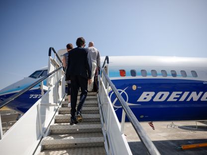 أشخاص يستقلون طائرة \"بوينغ 737 ماكس\" في معرض فارنبورو الدولي للطيران لعام 2022 في فارنبورو، المملكة المتحدة - المصدر: بلومبرغ