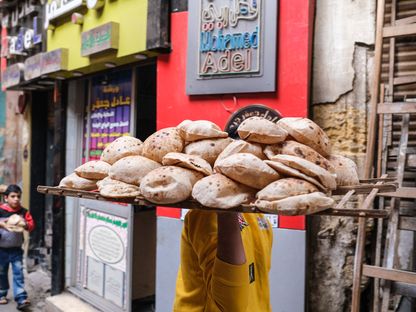 شخص يحمل الخبز الطازج على طبق قابل للتهوية في حي الخليفة في القاهرة، مصر - المصدر: بلومبرغ