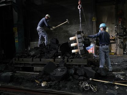 عمال يكسرون قوالب رملية مفتوحة لكشف مصبوبات الألومنيوم في مسبك شركة \"تاجيما\" للمعادن الخفيفة في هانيو، محافظة سايتاما، اليابان - المصدر: بلومبرغ