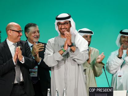سيمون ستيل، الأمين التنفيذي لاتفاقية الأمم المتحدة الإطارية بشأن تغير المناخ (إلى يسار الصورة) وسلطان الجابر، وعدد من المشاركين يصفقون في ختام فعاليات \"كوب 28\" في دبي - المصدر: بلومبرغ