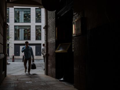 عامل يسير في زقاق في مدينة لندن، المملكة المتحدة - المصدر: بلومبرغ