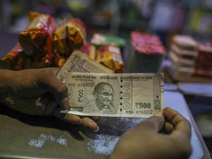 رجل ممسك بورقة نقدية فئة 500 روبية هندية، مومباي، في الهند - المصدر: بلومبرغ