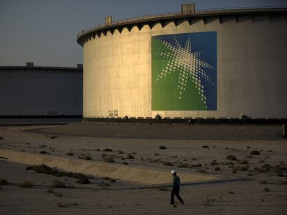 أحد العمال يسير بالقرب من صهاريج تخزين النفط في مصفاة \"أرامكو\" في رأس تنورة، المملكة العربية السعودية - المصدر: بلومبرغ