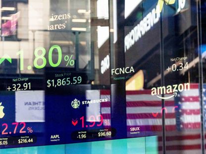 لوحة إلكترونية تبيّن أسعار عدد من الأسهم خلف الزجاج في سوق ناسداك بنيويورك، الولايات المتحدة - بلومبرغ