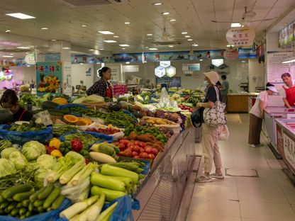 إحدى الزبائن تشتري في سوق للخضروات الطازجة بشنغهاي، الصين - المصدر: بلومبرغ