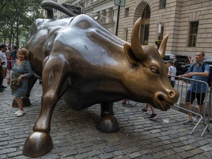 زوار حول تمثال \"الثور الهائج\" (Charging Bull) بالقرب من بورصة نيويورك (NYSE) في نيويورك، الولايات المتحدة، يوم الخميس 29 يونيو 2023. - المصدر: بلومبرغ