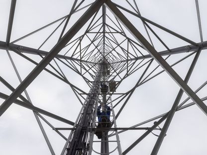مهندسون يصعدون سلم صيانة برج اتصالات في سان بطرسبرغ، روسيا. - المصدر: بلومبرغ