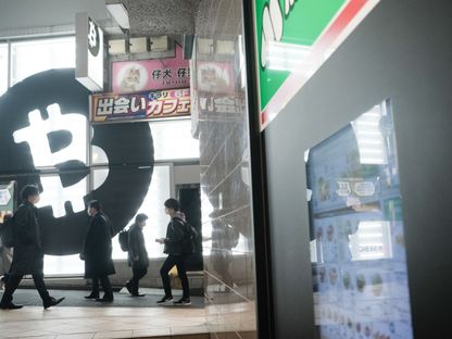 مشاة يمرون أمام متجر \"ساكورا اكستشينج بتكوين\" في حي شيبويا، طوكيو، اليابان  - المصدر: بلومبرغ