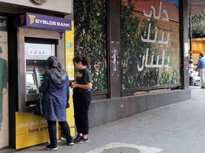 عميلتان تستخدمان جهاز صراف آلي خارج فرع تابع لبنك \"بيبلوس\" في بيروت، لبنان. - المصدر: بلومبرغ