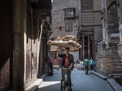 راكب دراجة يحمل طاولة من الخبز فوق رأسه بالقاهرة، مصر - المصدر: بلومبرغ