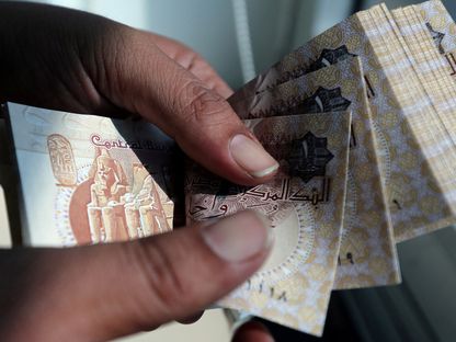 رجل يعد أوراق نقدية من فئة جنيه - المصدر: رويترز