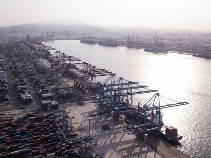سفن الشحن ترسو تحت الرافعات في حين تستقر حاويات الشحن بمحطة حاويات تشينغداو تشيانوان في الصين  - المصدر: بلومبرغ