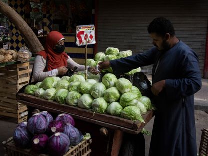 أحد الزبائن يدفع لبائع أغذية في سوق المنيرة في القاهرة، مصر، يوم الأربعاء، 1 يونيو 2022 - المصدر: بلومبرغ