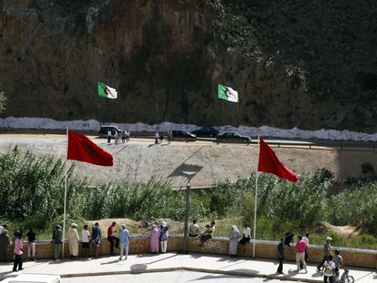 أشخاص يقفون على جانبي نقطة حدودية بين المغرب والجزائر شمال شرق المغرب - المصدر: رويترز