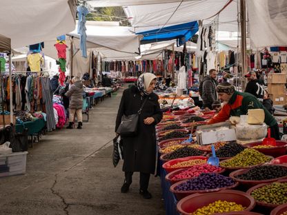 متسوقة تتجول أمام بائع زيتون طازج في سوق أورتاكوي في إسطنبول، تركيا - المصدر: بلومبرغ