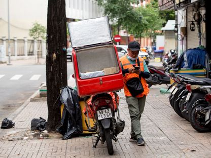 سائق توصيل الطلبات ينتظر عميلاً في مدينة هو تشي مينه ، فيتنام. - المصدر: بلومبرغ