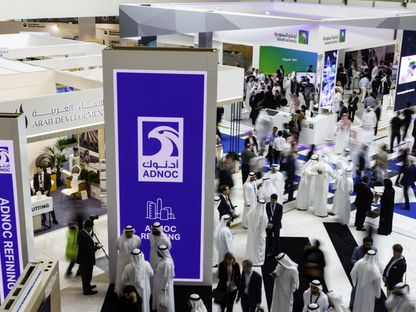المندوبون يستعرضون عروض \"أدنوك\" وأرامكو\" خلال معرض ومؤتمر أبوظبي الدولي للبترول \"أديبك\" في أبوظبي، الإمارات العربية المتحدة - المصدر: بلومبرغ