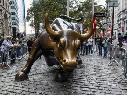 زوار ملتفون حول تمثال \"الثور الهائج\" (Charging Bull) قرب بورصة نيويورك، 27 أكتوبر 2023 - المصدر: بلومبرغ