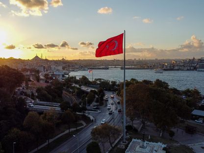 علم تركيا بجانب مضيق البوسفور خلال غروب الشمس في اسطنبول، تركيا. - المصدر: بلومبرغ