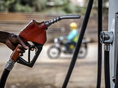 عامل يحمل مضخة وقود في محطة بنزين على جانب الطريق في ضاحية هوروما في نيروبي، كينيا  - المصدر: بلومبرغ