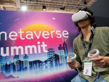 شخص يستخدم نظارة وسماعة الواقع الافتراضي خلال قمة \"ميتافيرس\" التي عُقدت ضمن مؤتمر \"باريس إن إف تي داي\"، بفرنسا، بتاريخ 12 إبريل 2022 - المصدر: بلومبرغ