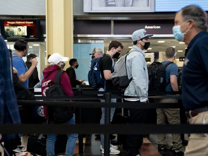 مسافرون يرتدون أقنعة واقية داخل مطار رونالد ريغان في آرلينغتون، فيرجينيا - المصدر: بلومبرغ