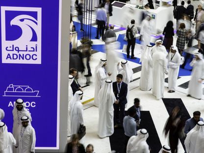 المندوبون يجتازون عرض شركة أدنوك خلال معرض ومؤتمر أبوظبي الدولي للبترول \"أديبك\" في أبوظبي، الإمارات العربية المتحدة - المصدر: بلومبرغ