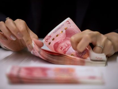 موظف يعد  أوراقاً نقدية صينية فئة 100 يوان في مقر بنك هانغ سانغ  - المصدر: بلومبرغ